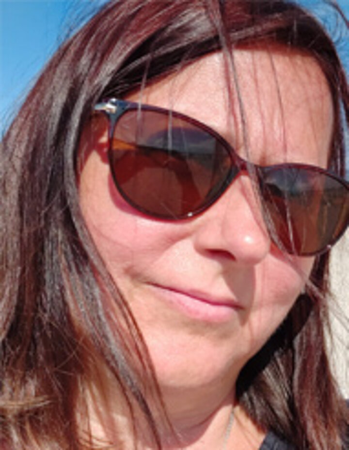 Zdjęcie twarzy kobiety w okularach przeciwsłonecznych.
