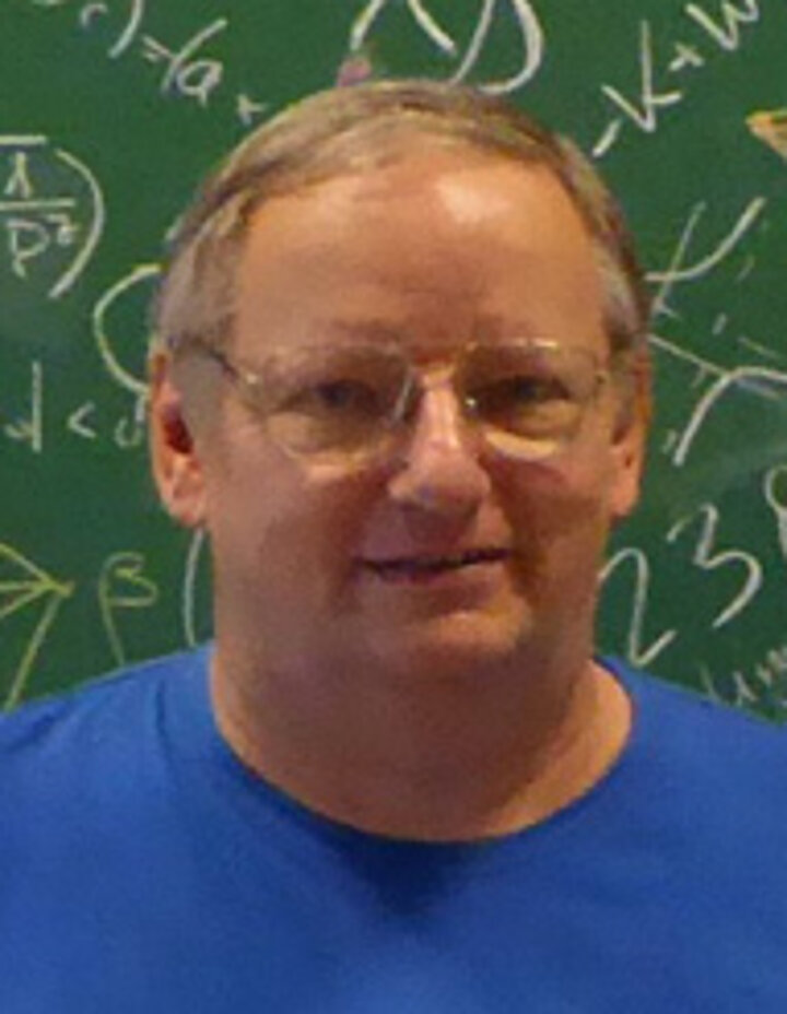 Zdjęcie portretowe mężczyzny w okularach i niebieskim t-shircie.